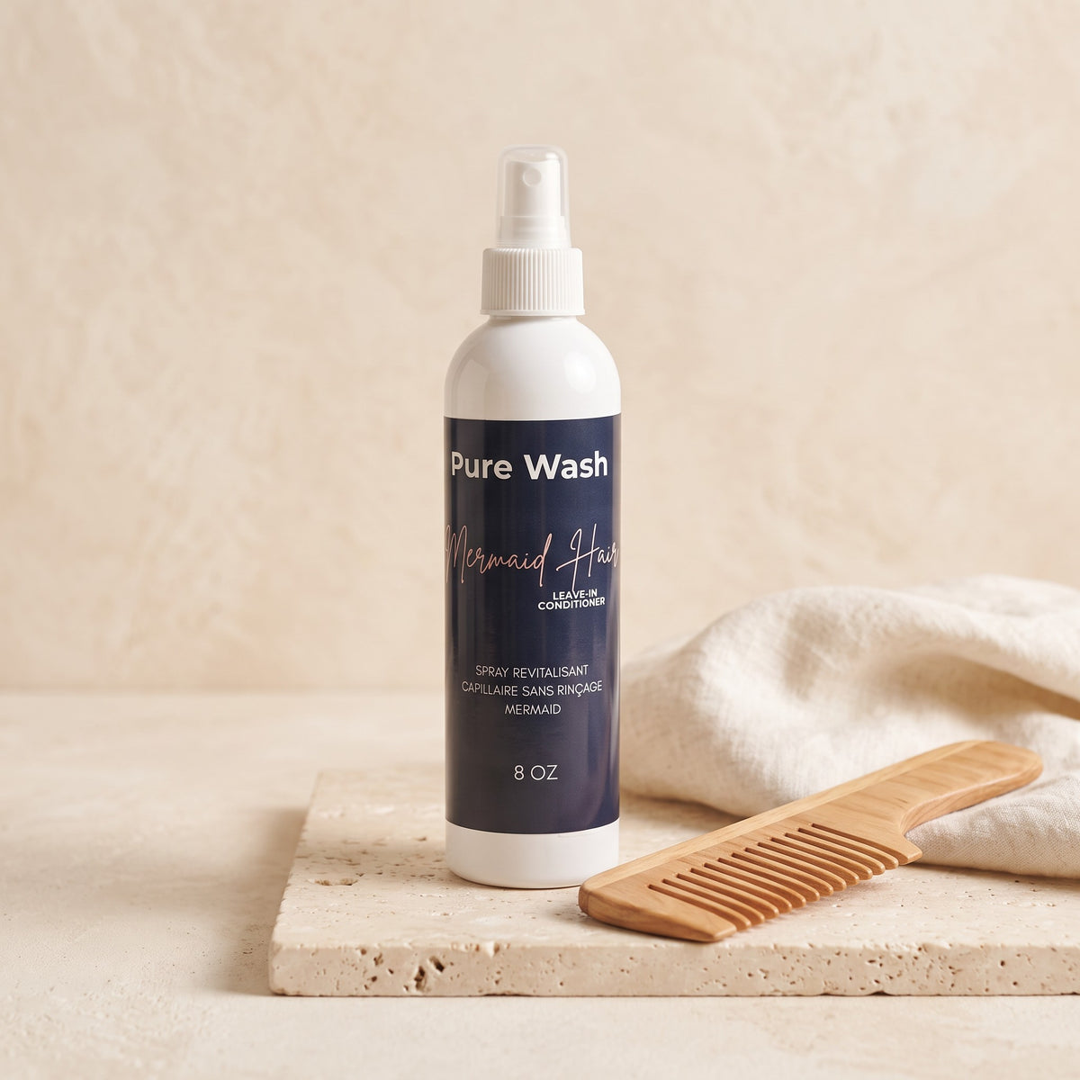 Pure Wash Leave-In Mermaid Hair Conditioner spray bottle with a wooden comb on a stone surface