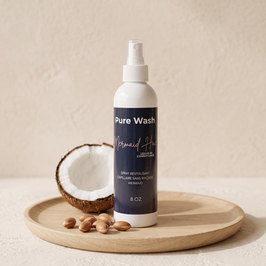 Pure Wash Mermaid Hair leave-in conditioner spray bottle with coconut and argan oil on a wooden tray.