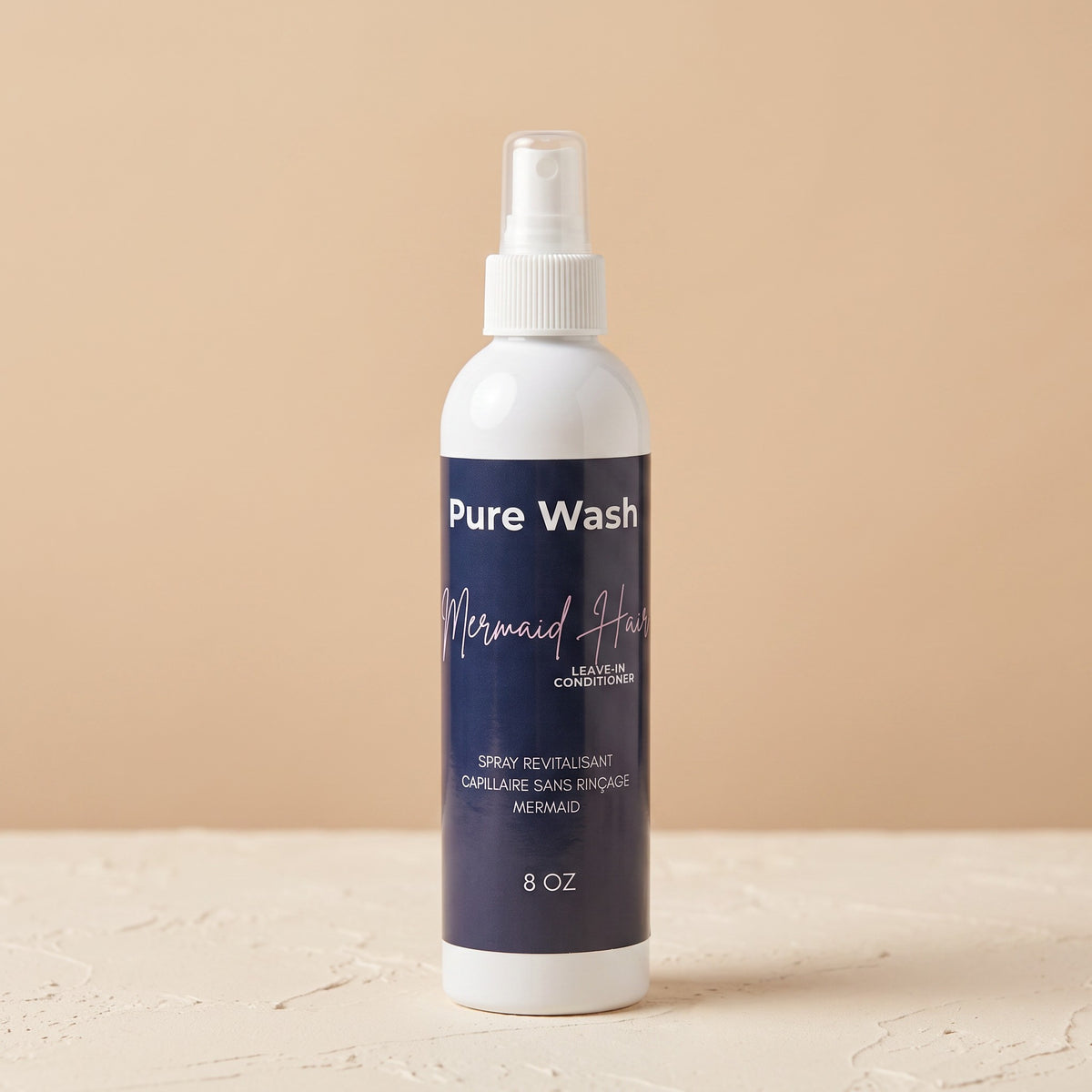 Pure Wash Leave-In Mermaid Hair conditioner spray bottle in 8 oz size with a white pump on a beige background.