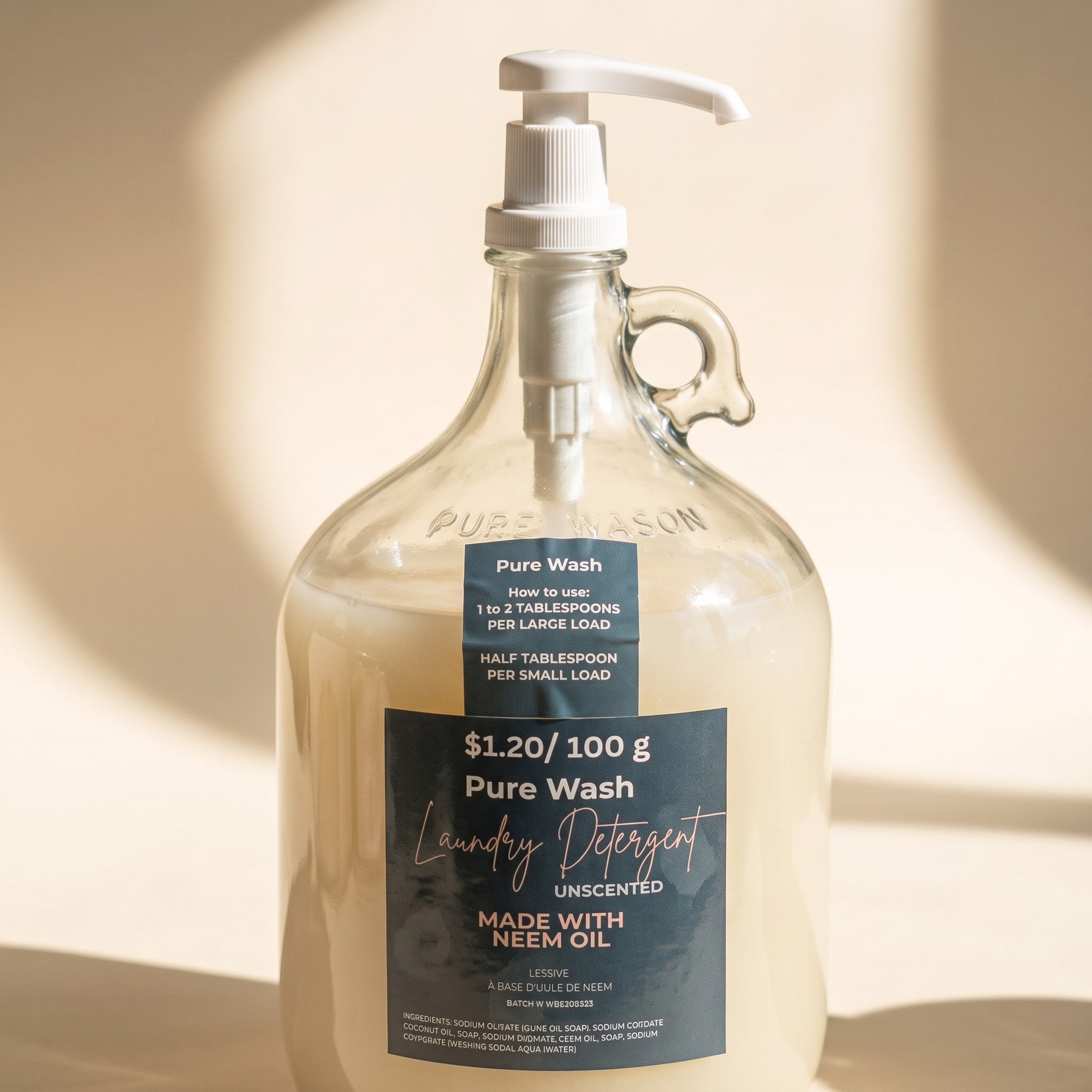Pure Wash laundry detergent in a clear glass refillable jug with a pump dispenser and neem oil label.