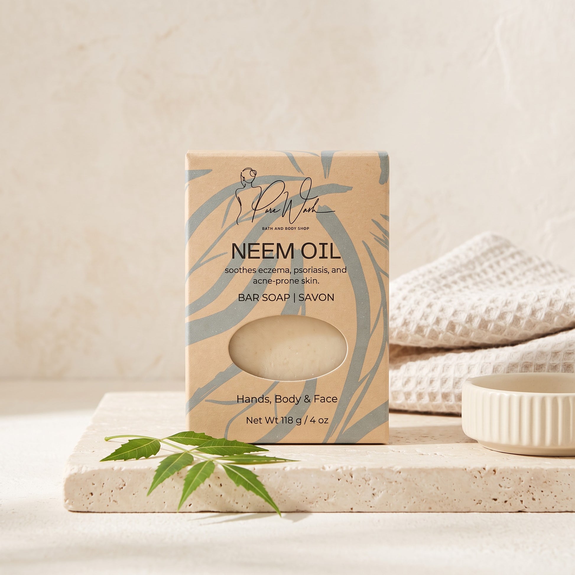Pure Wash Neem Oil soap bar in eco-friendly packaging on a stone tray with a green leaf and white towel