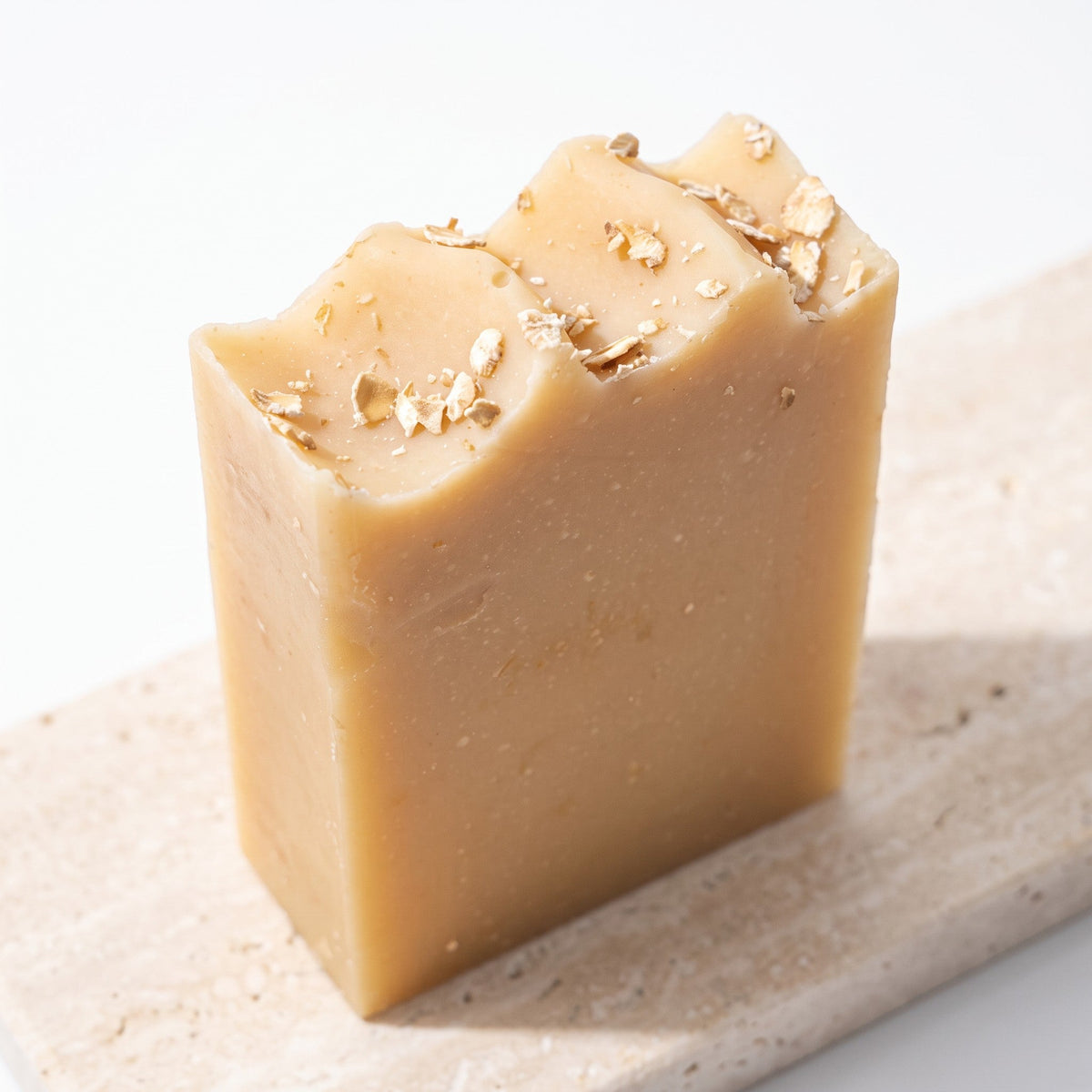 Pure Wash oatmeal milk and honey soap bar with visible oat flakes on a textured stone surface