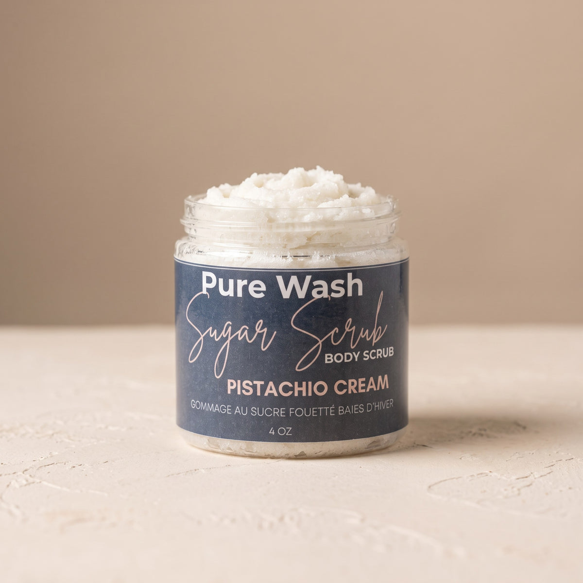 Pure Wash Pistachio Cream body sugar scrub in a clear jar with a blue label, featuring exfoliating cane sugar texture.