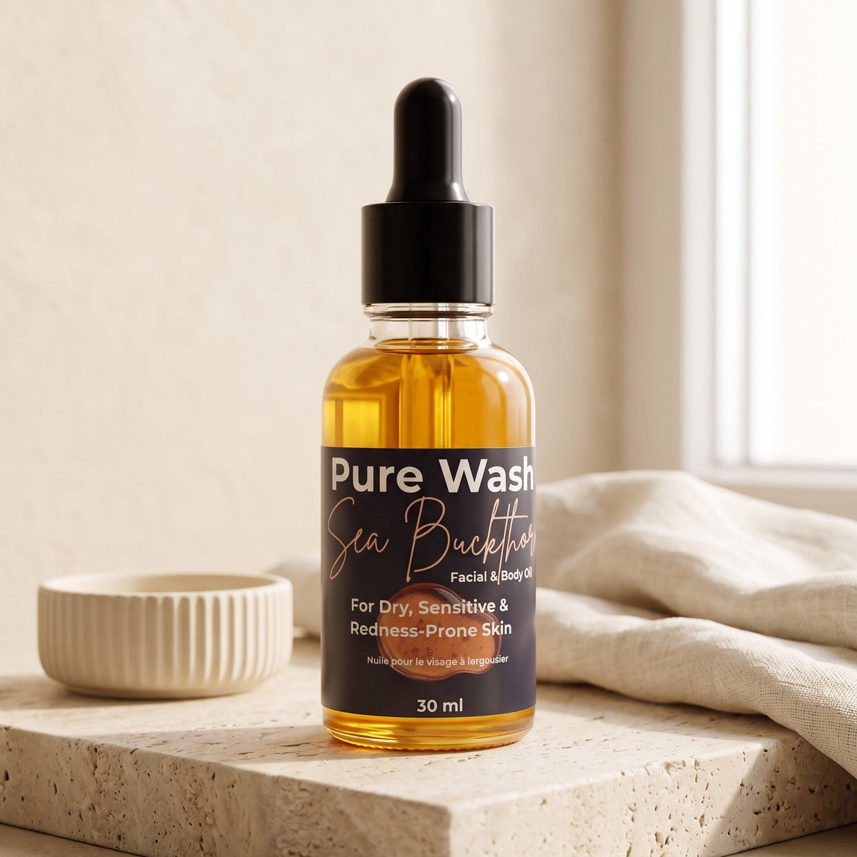 Pure Wash Sea Buckthorn facial oil in a 30ml amber glass dropper bottle on a textured stone surface.