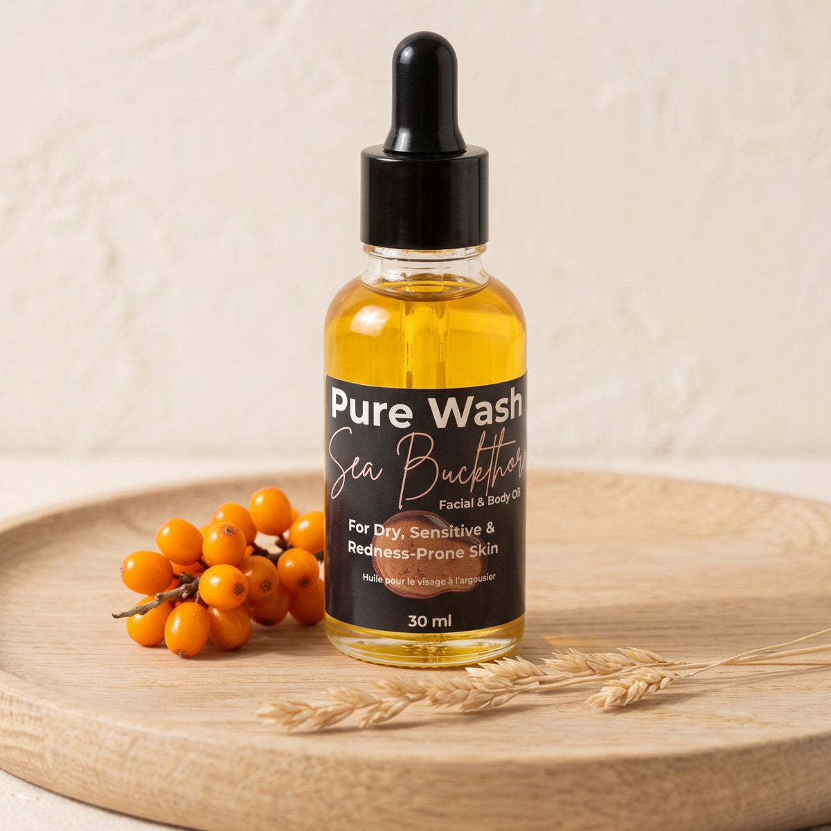 Pure Wash Sea Buckthorn facial oil in a glass dropper bottle with orange berries on a wooden tray.