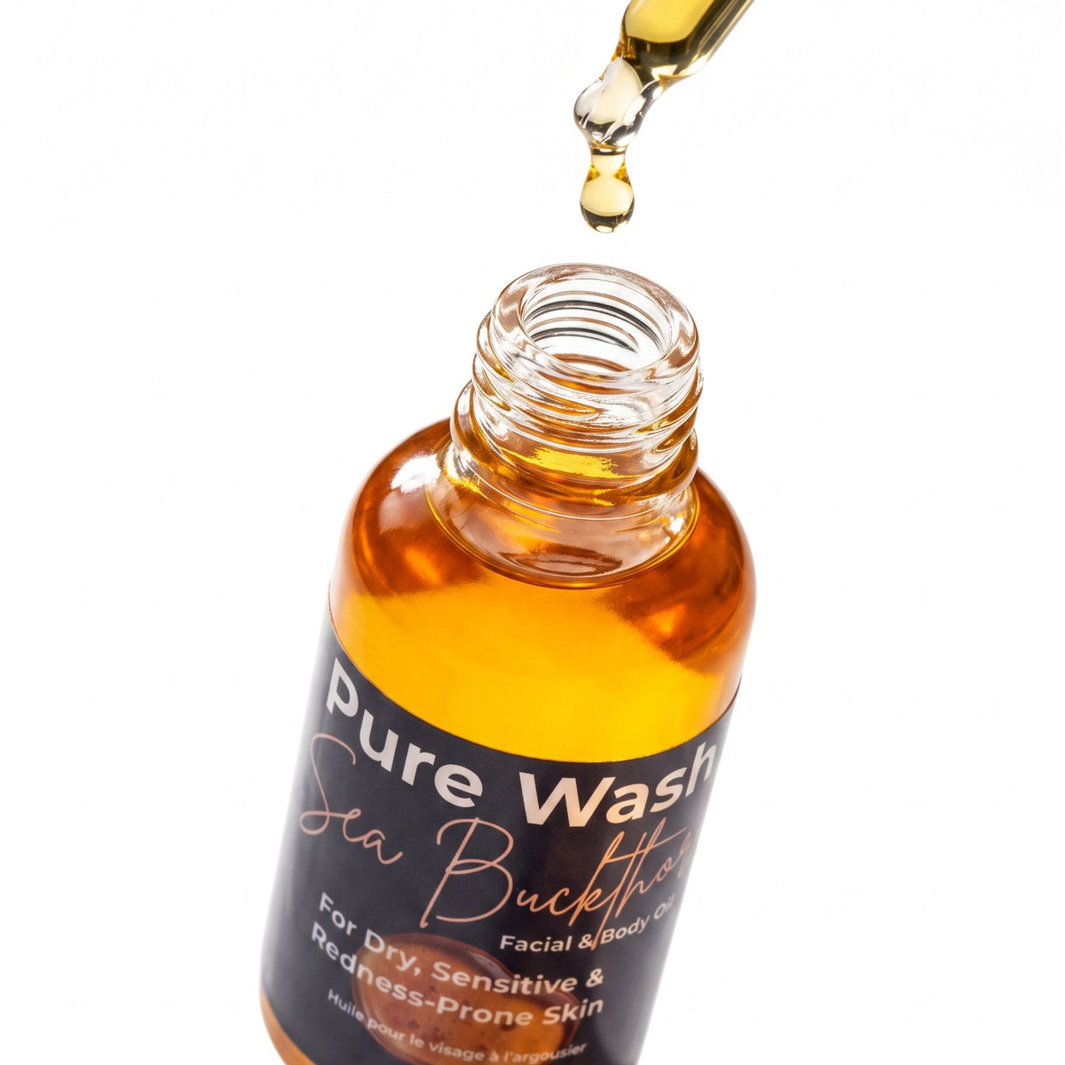 Pure Wash Sea Buckthorn facial oil in a glass bottle with a dropper dispensing golden oil for sensitive skin