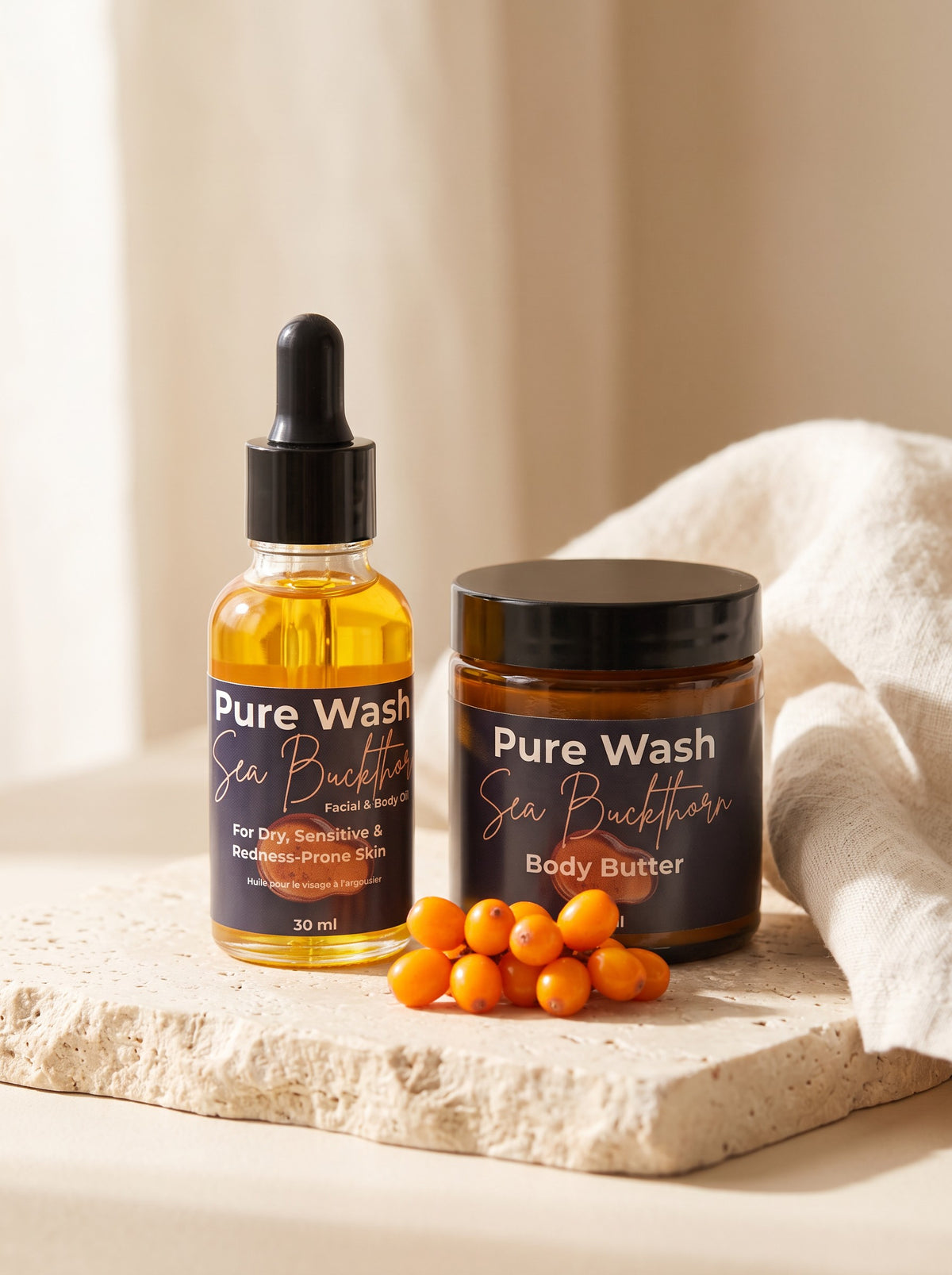 Pure Wash Sea Buckthorn facial oil and body butter set with fresh orange berries on a textured stone surface