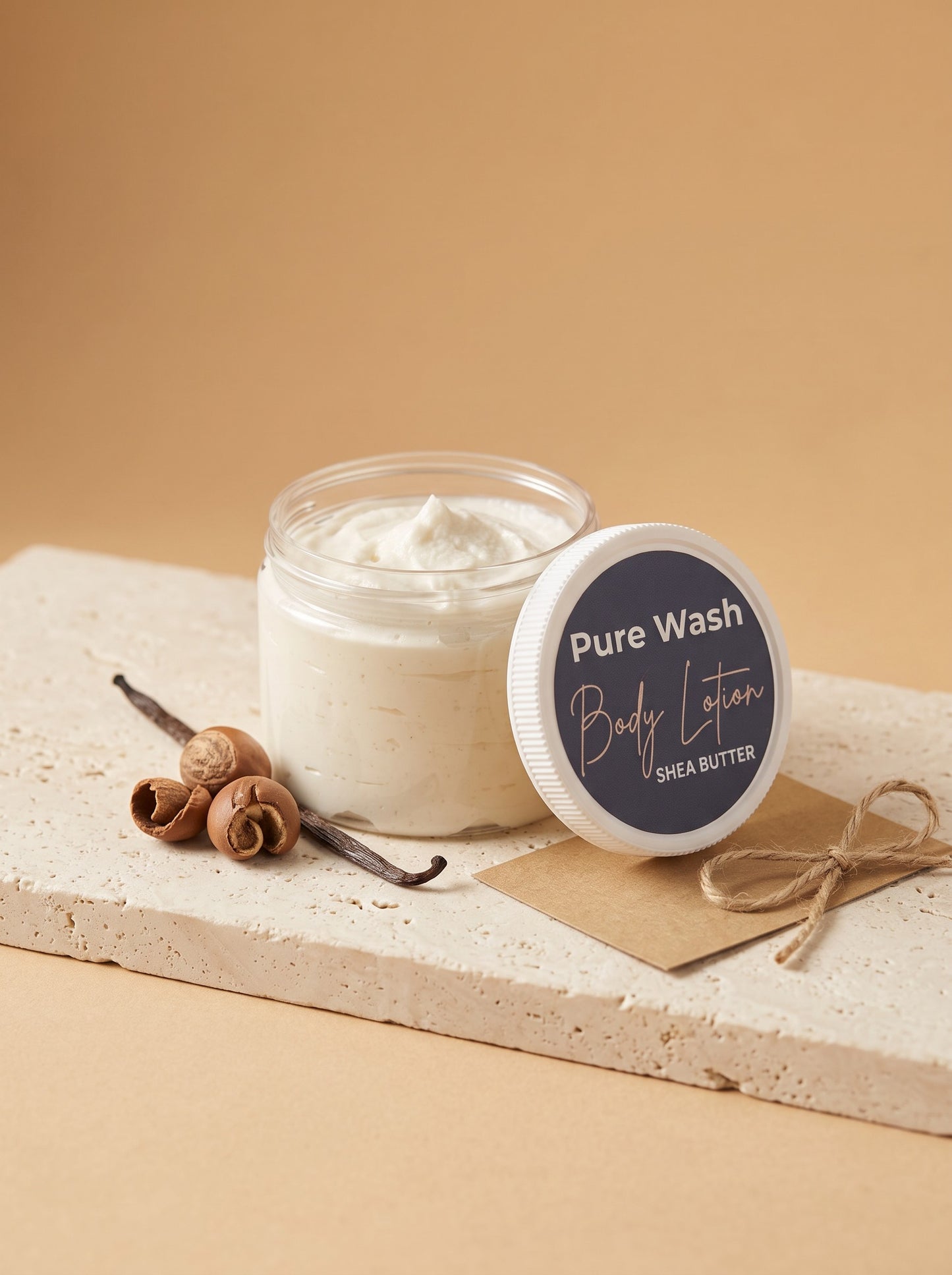 Pure Wash shea butter body lotion in a clear jar with vanilla beans and hazelnuts on a stone display base.