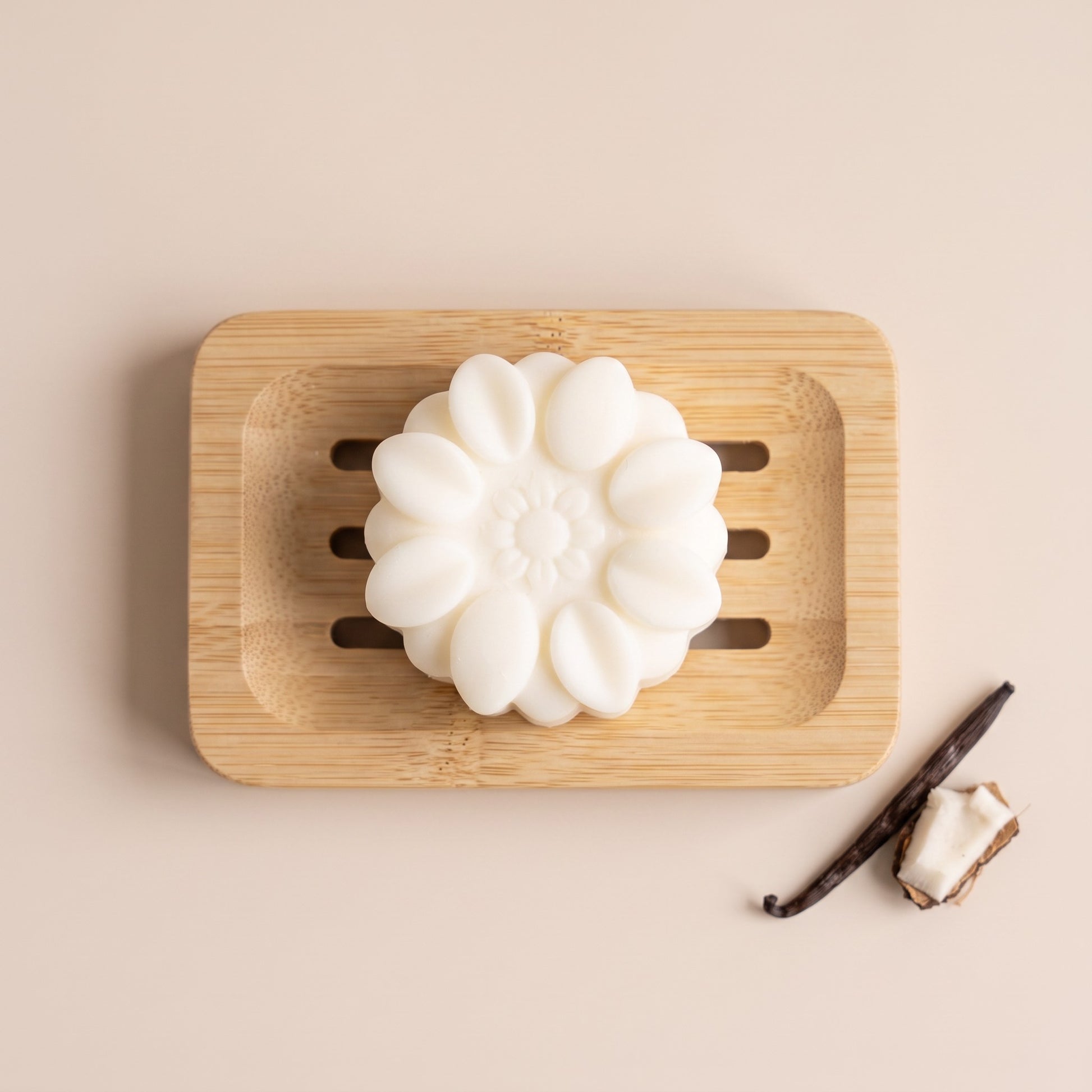 Pure Wash solid body lotion bar with shea butter and coconut oil on a wooden soap dish with vanilla and coconut