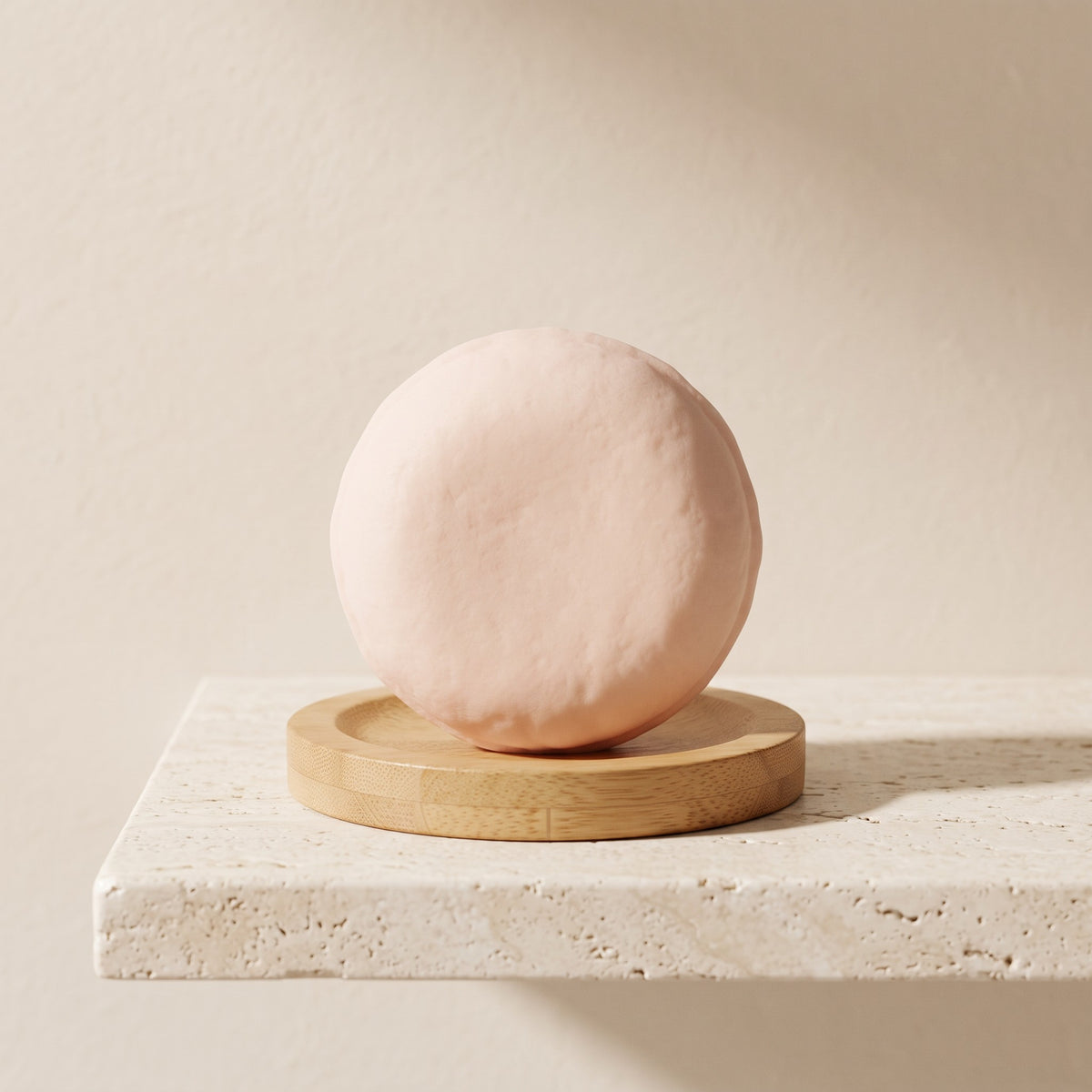 Pure Wash solid shampoo bar in soft pink resting on a round wooden soap dish against a neutral textured background.