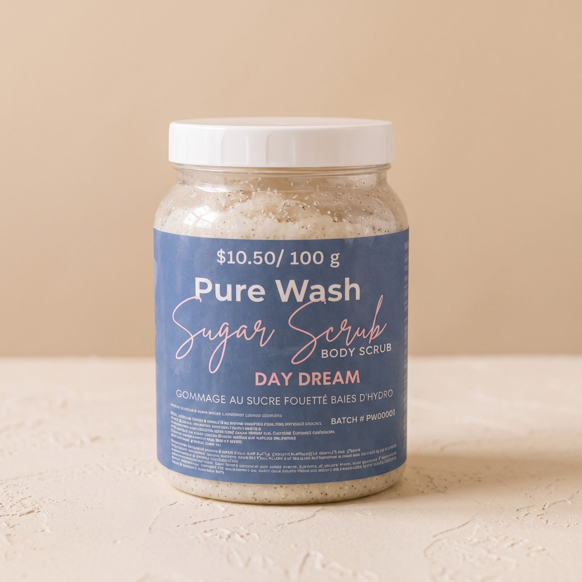 Pure Wash Day Dream sugar body scrub in a clear plastic jar with a white lid, featuring coconut and vanilla scent.