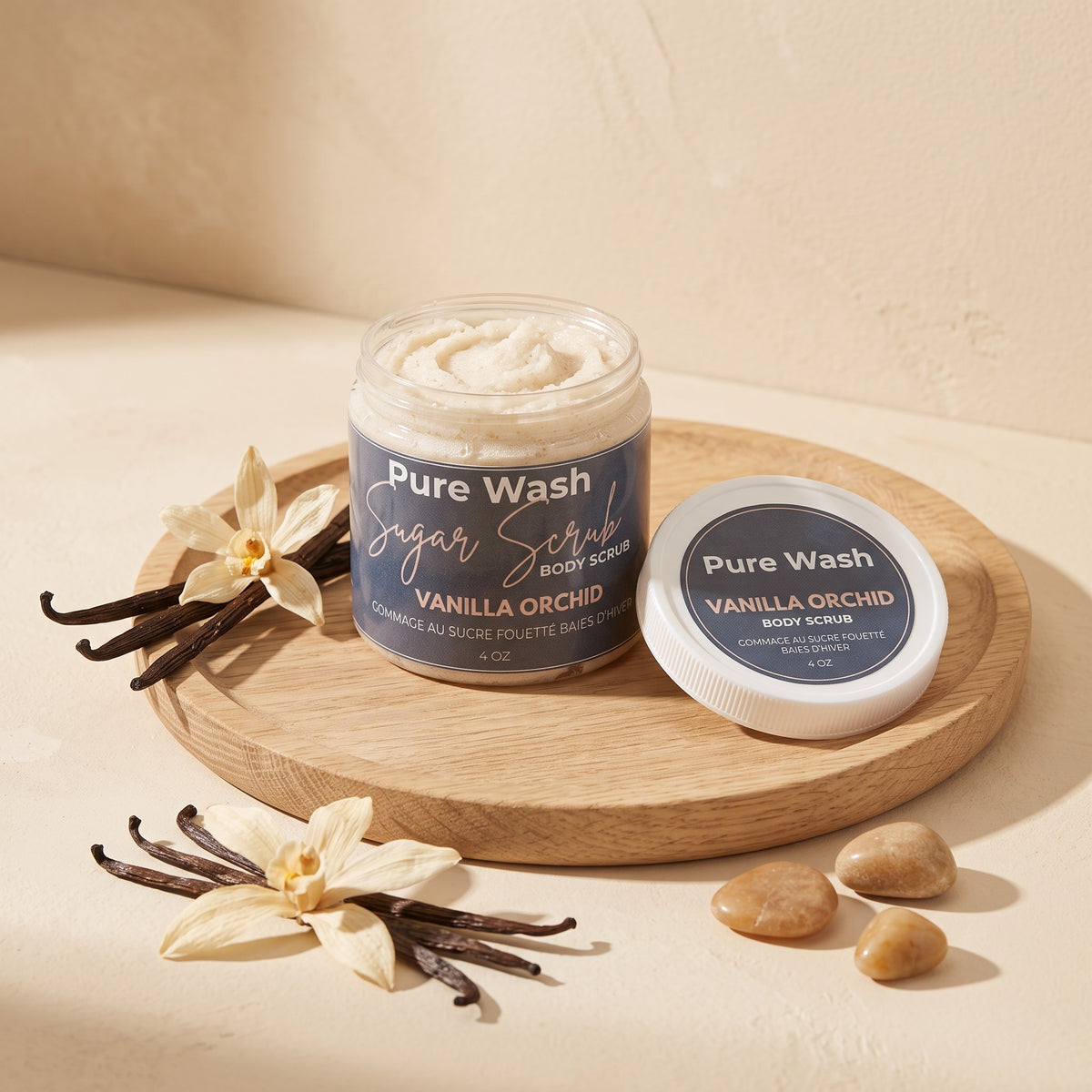 Pure Wash Vanilla Orchid body sugar scrub in a jar with lid, displayed on a wooden tray with vanilla flowers.