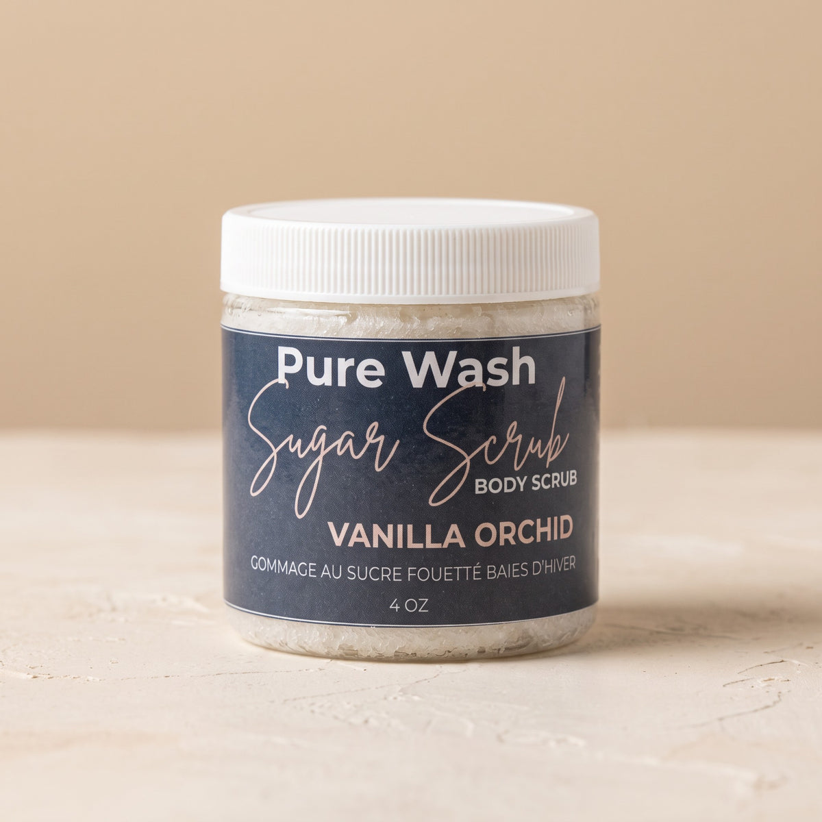 Pure Wash Vanilla Orchid body sugar scrub in a clear jar with a white lid for exfoliating and moisturizing skin.