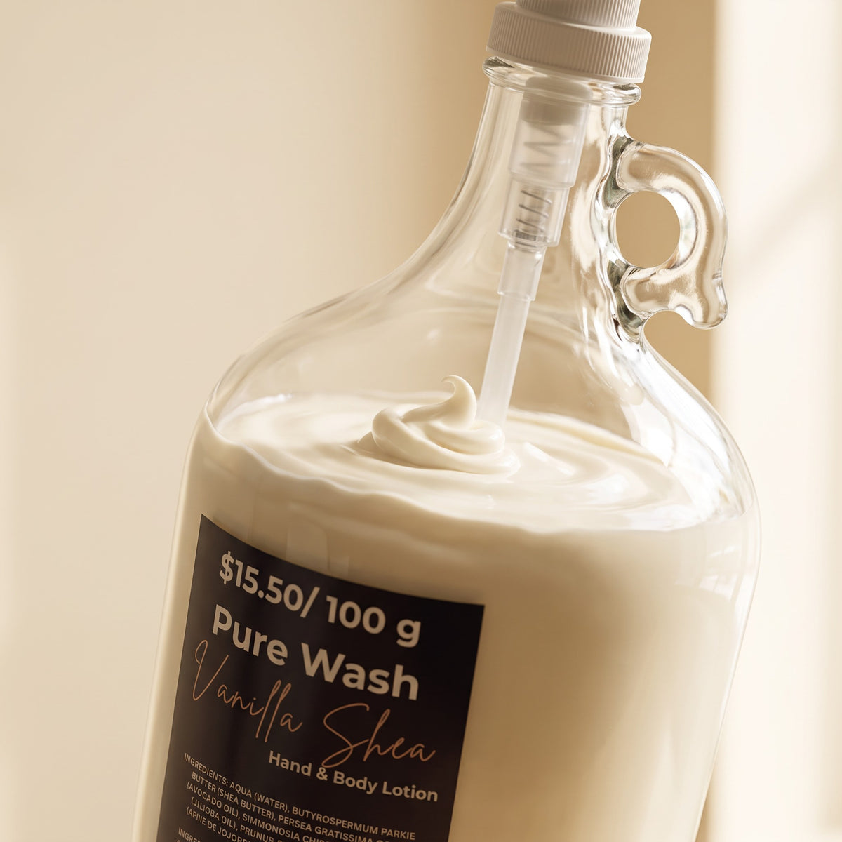 Pure Wash Vanilla Shea body lotion in a refillable glass jug with a pump dispenser for hands and body.