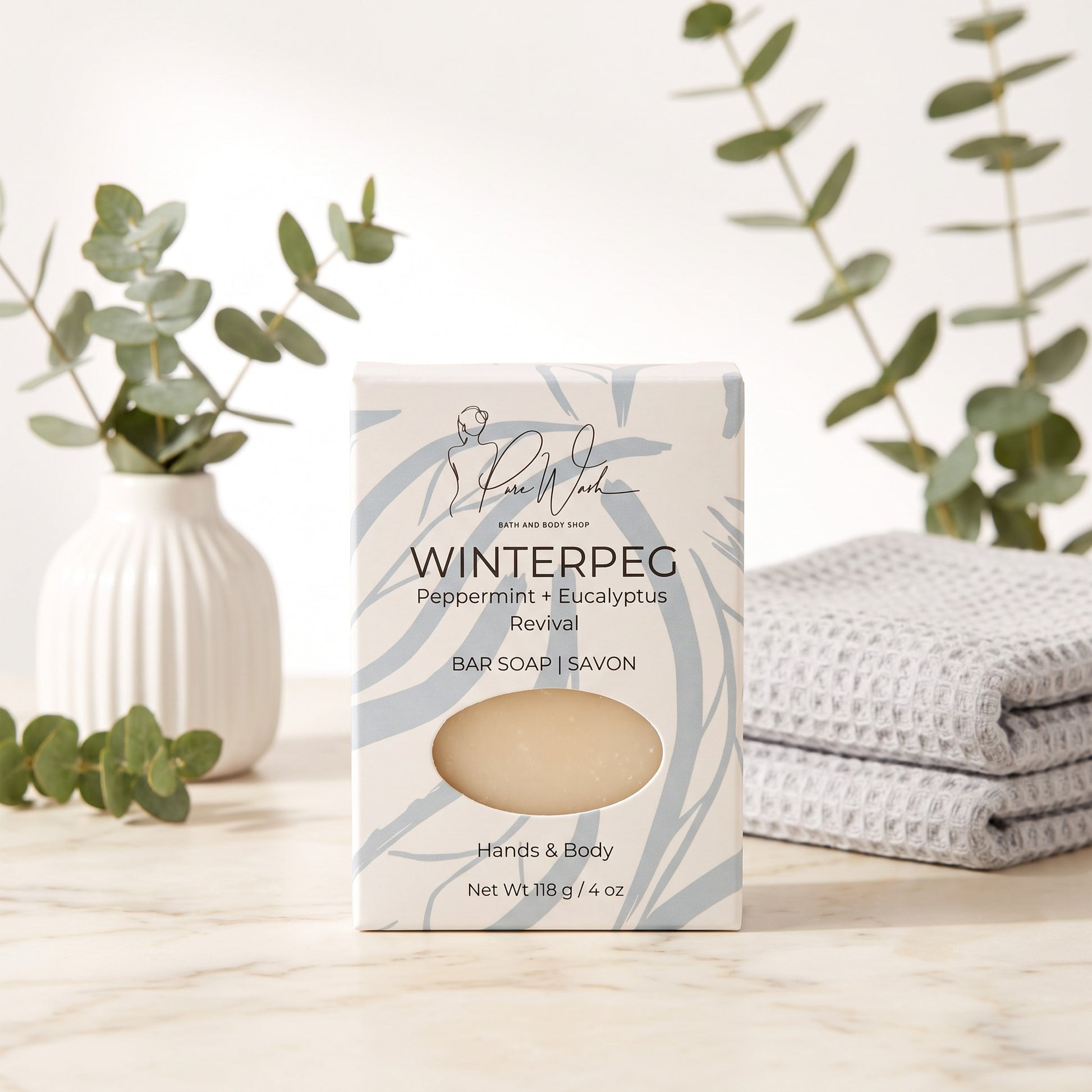 Pure Wash WinterPeg peppermint and eucalyptus soap bar in decorative packaging on a marble surface with eucalyptus.
