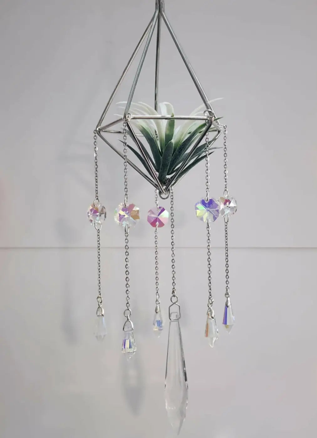 Geometric silver metal pyramid air plant suncatcher with dangling crystal charms and a small air plant inside
