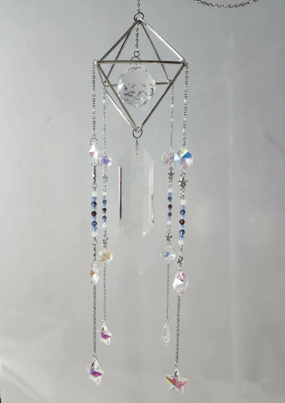 Pyramid suncatcher featuring a delicate silver geometric frame with a crystal orb and iridescent bead charms, canadian made skincare