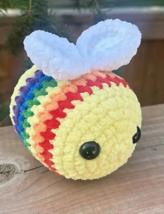 A crocheted rainbow bee with white wings and black button eyes perfect for handmade soap canada and pure wash gifts