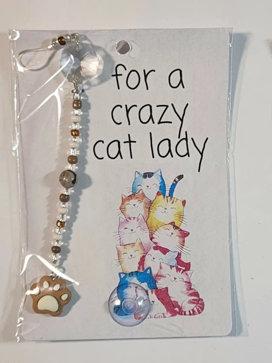 Small cat suncatcher featuring clear beads with a silver hook and brown paw print pendant for decorative use