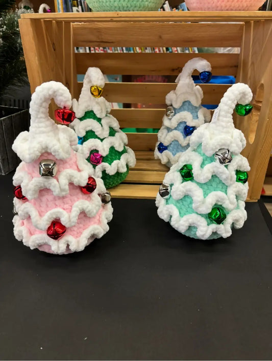 Small christmas tree crocheted ornaments in pink green and teal with white snow trim and metallic bells