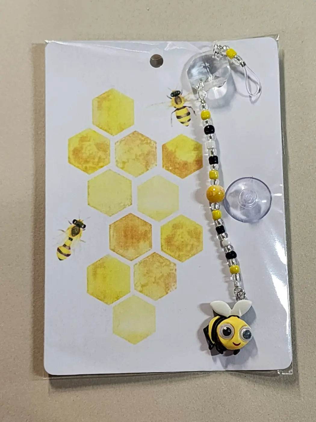 Small suncatcher featuring a cheerful yellow and black bee charm with googly eyes on a beaded chain for natural skincare canada