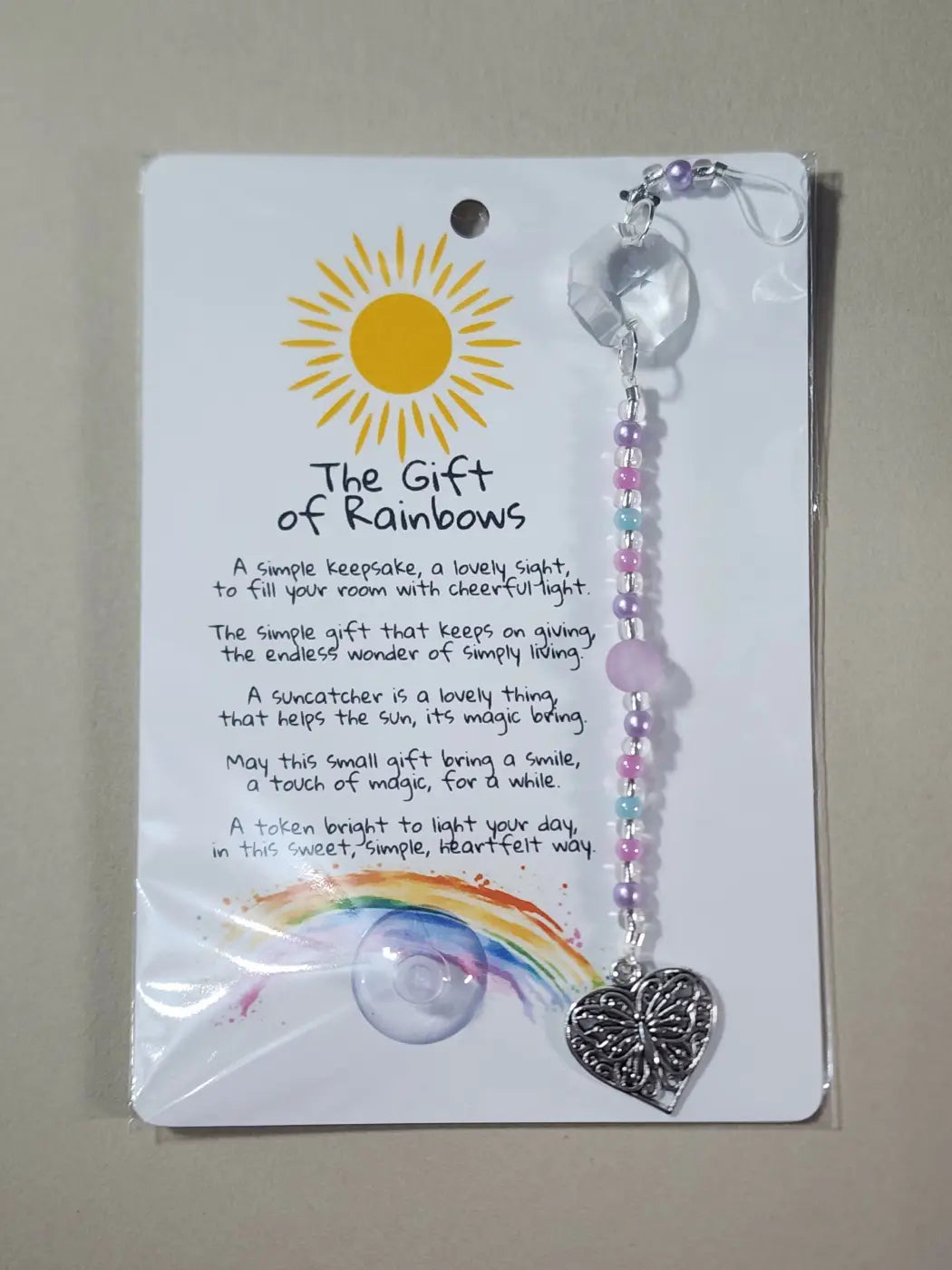 Small suncatcher with a clear crystal top, pastel pink and purple beads, and a silver heart charm, ideal for canadian made skincare spaces
