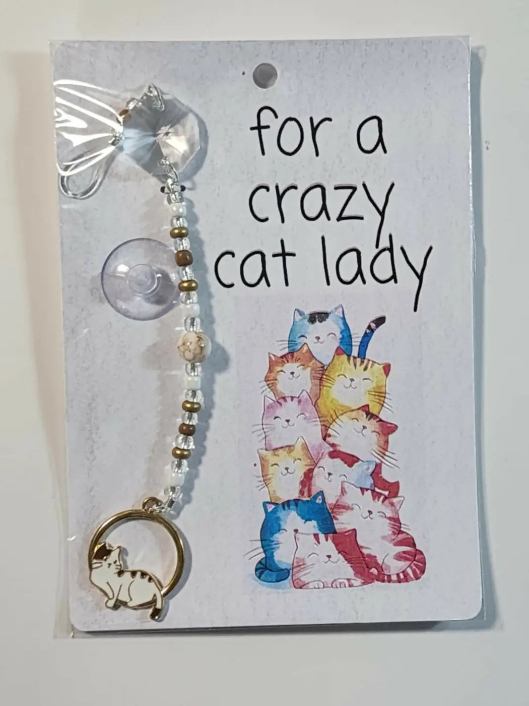 Small suncatcher featuring a clear faceted crystal charm with suction cup and gold-toned cat pendant, ideal for natural skincare canada spaces