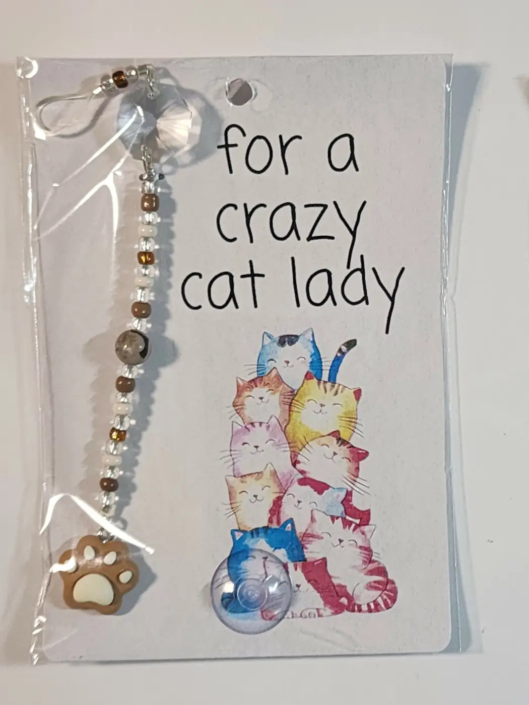 Small suncatcher featuring a clear dangling cat toy with silver clasp and beaded chain for canadian made skincare fans