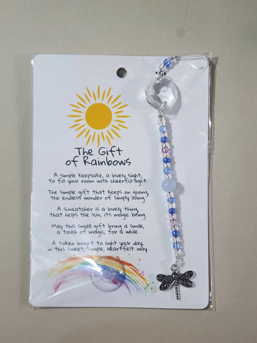 Small suncatcher featuring a clear faceted crystal with a dragonfly charm and blue and purple beads, perfect for canadian made skincare spaces
