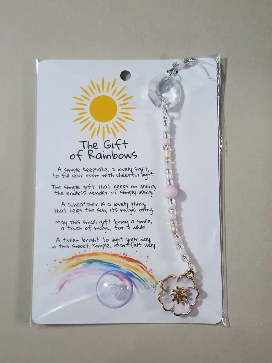 Small suncatcher with delicate pink and clear beads floral design and gold accents promoting canadian made skincare aesthetic