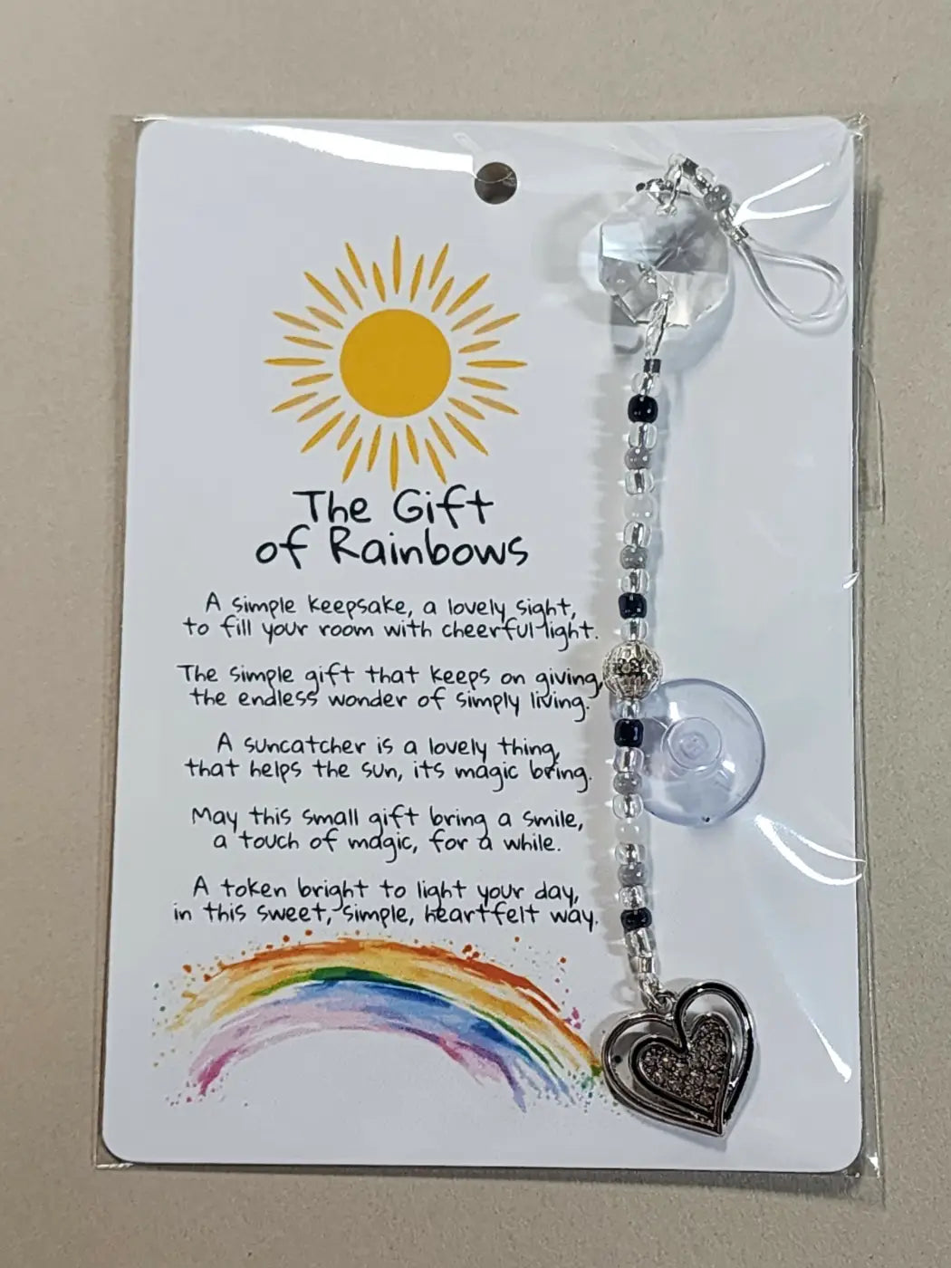 Small suncatcher clear crystal with silver heart charm and black beads packaged on the gift of rainbows card canadian made skincare