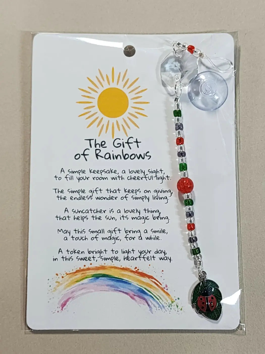 Small suncatcher with clear pendant and beaded chain in red green and silver featuring a black ladybug charm for canadian made skincare gift ideas