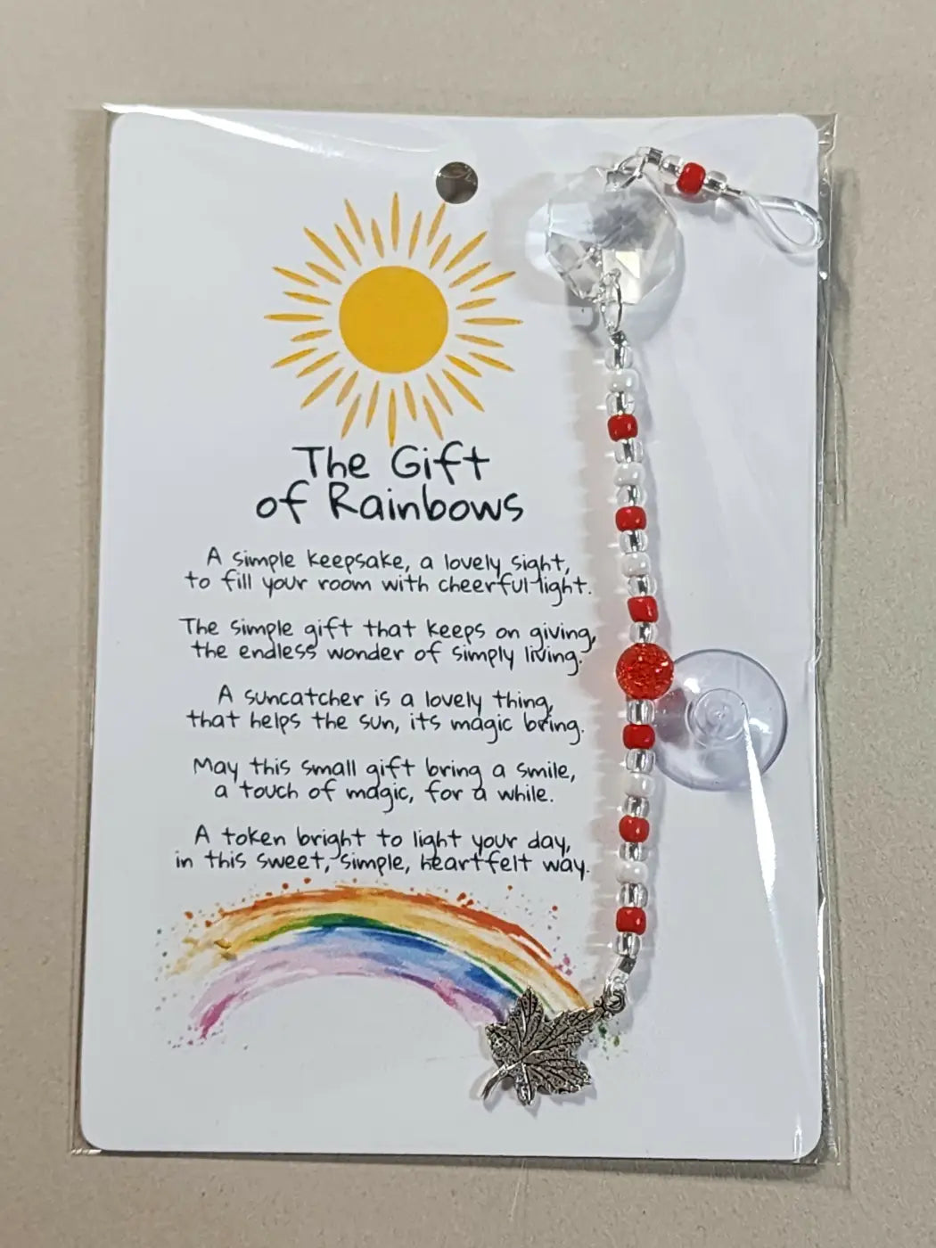 Small suncatcher with red and clear beads and silver maple leaf charm highlighting canadian made skincare artistry