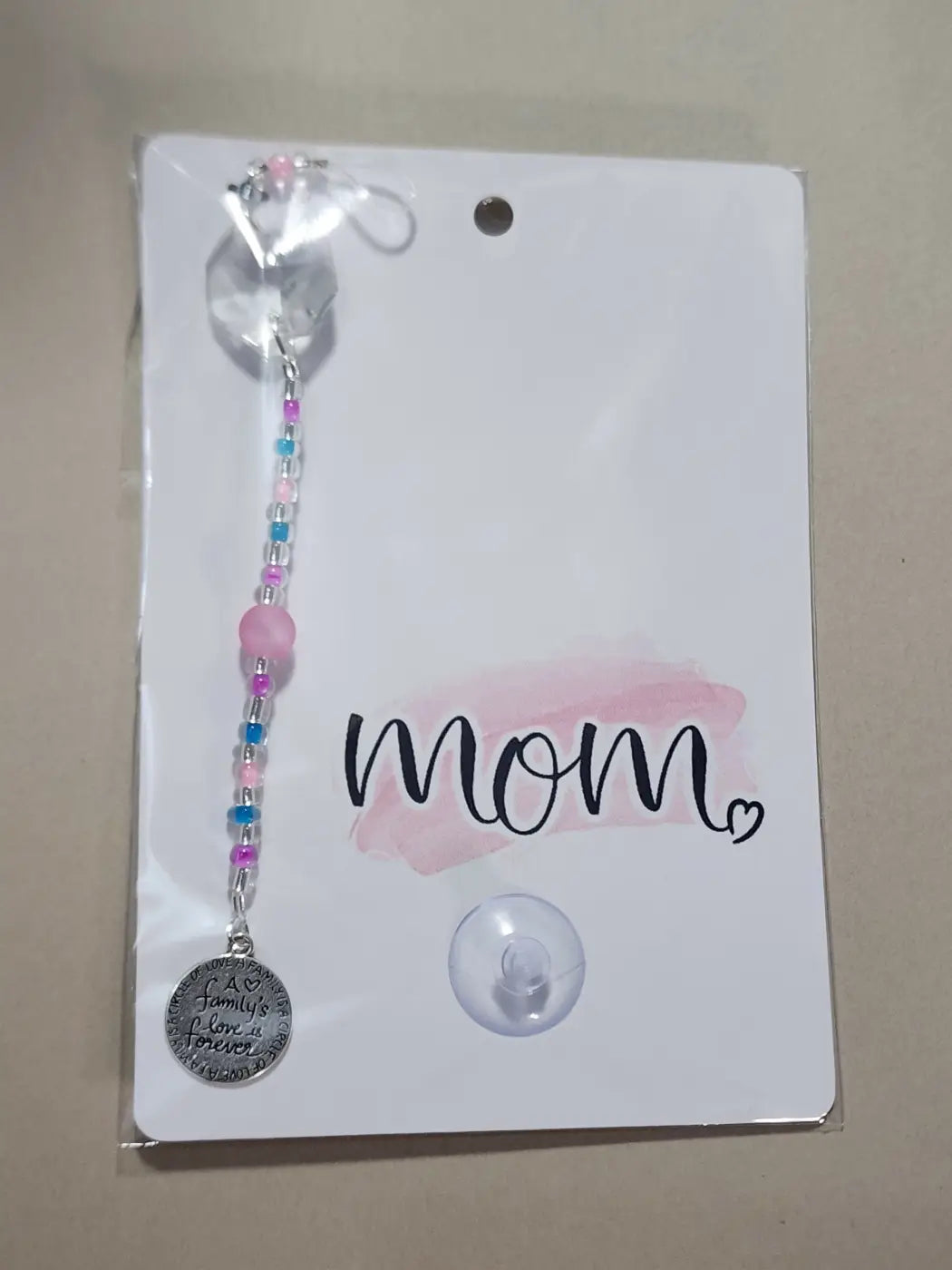 Small suncatcher featuring a delicate pink and blue beaded carabiner charm with a silver mom pendant, ideal for canadian made skincare gifts