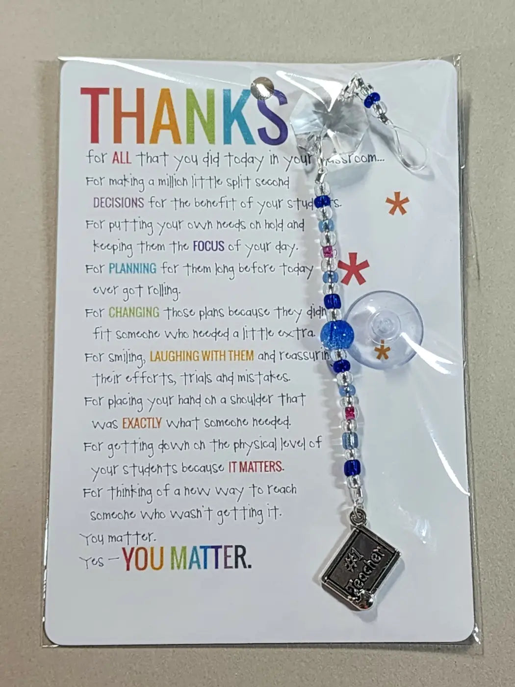 Small suncatcher blue and silver beaded lanyard with clear suction cup and metallic book charm ideal for canadian made skincare display