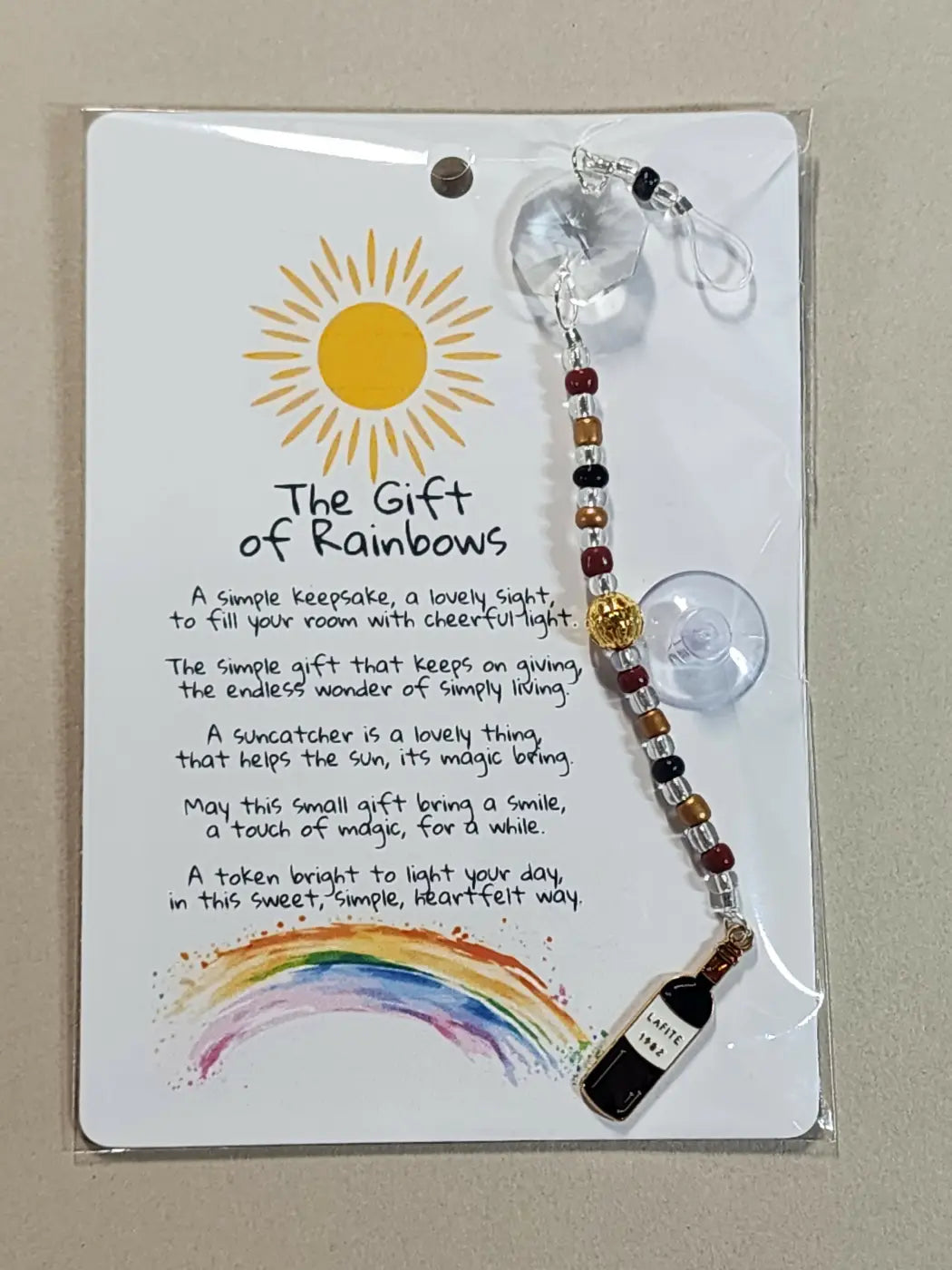 Small suncatcher with clear faceted crystal charm and red black gold beaded chain ending in canadian made skincare pendant