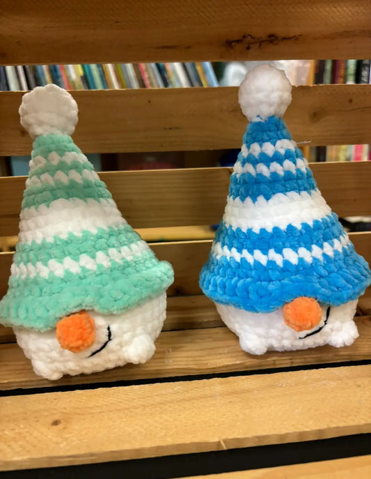 Two handmade crocheted snowman gnomes in mint green and blue stripes with white pom-pom hats for natural skincare canada