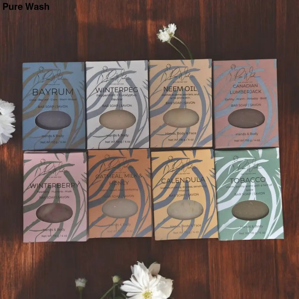 Set of nine soap packages with floral designs on a wooden surface.