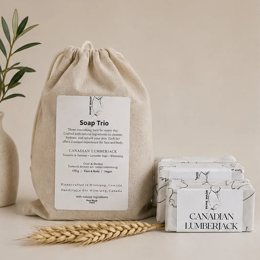 Beige linen canvas drawstring bag labeled soap trio containing three white botanical soap bars with canadian lumberjack design