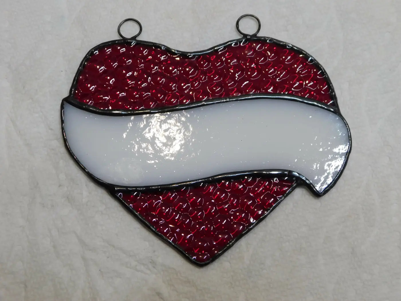 Stained glass red and white heart with textured glossy finish and black leaded edges showcasing friendly staff design