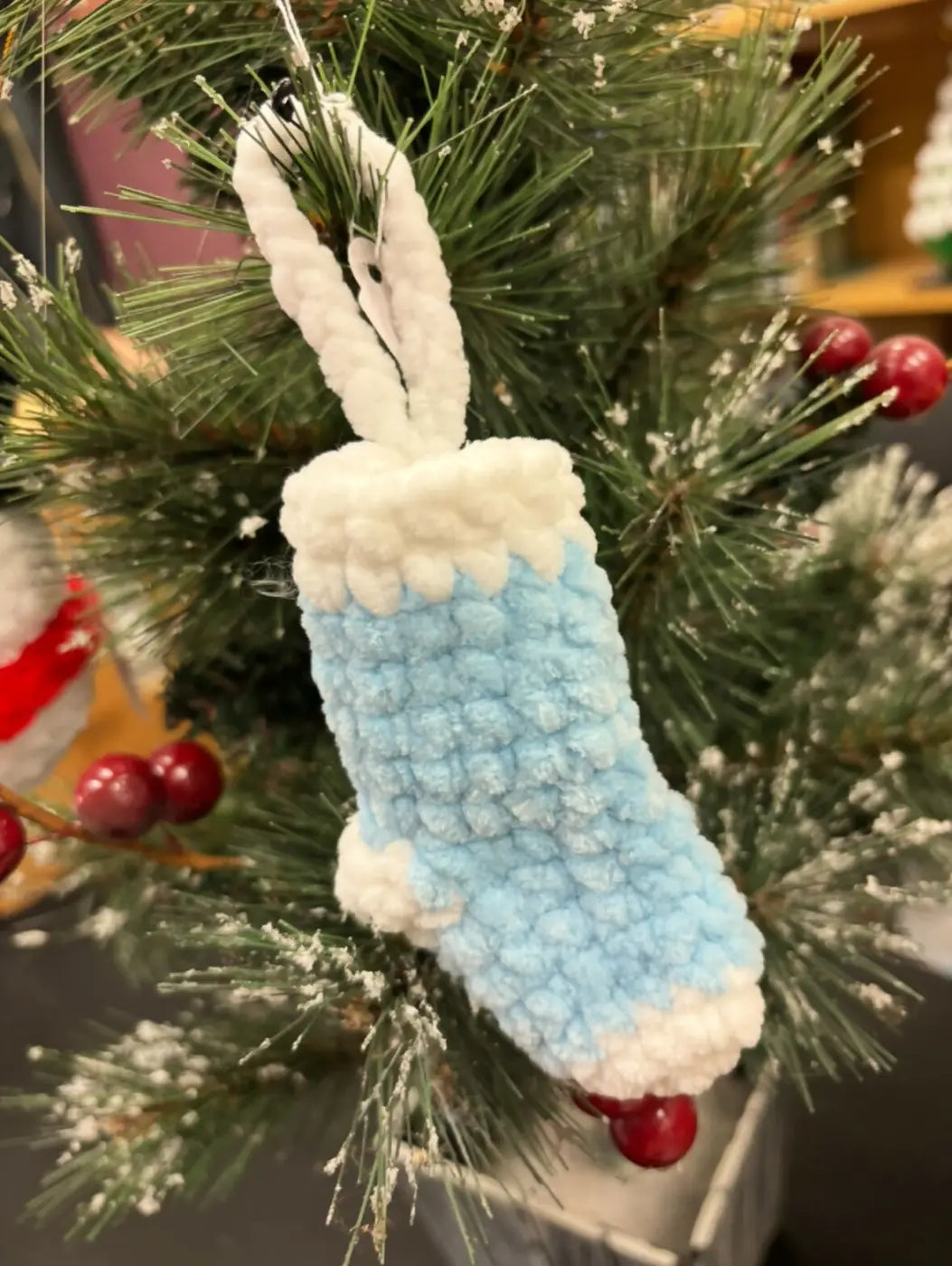 A hand-crocheted light blue and white stocking ornament with a textured fuzzy finish for natural skincare Canada