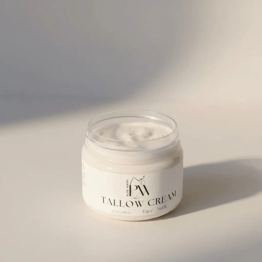 A clear glass jar of creamy white tallow cream with minimalist black text label featuring pure wash tallow and avocado oil