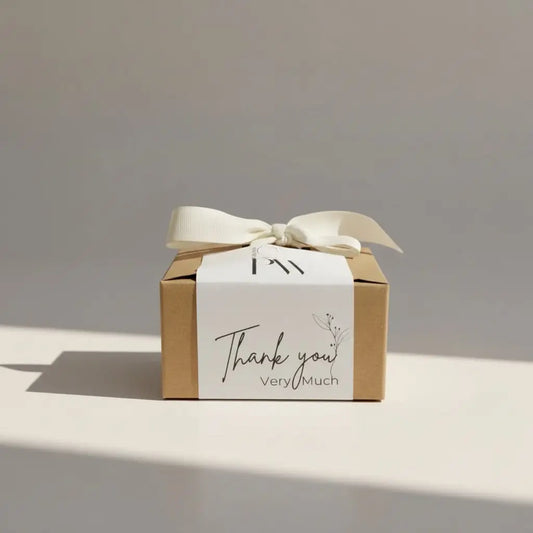 A minimalist brown kraft paper thank you gift box canada with a white ribbon bow and appreciation message label