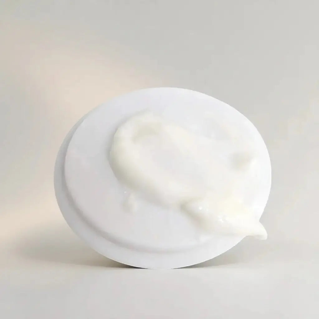White plastic lid with creamy white yogurt atop from the it line skincare complete skincare bundle product
