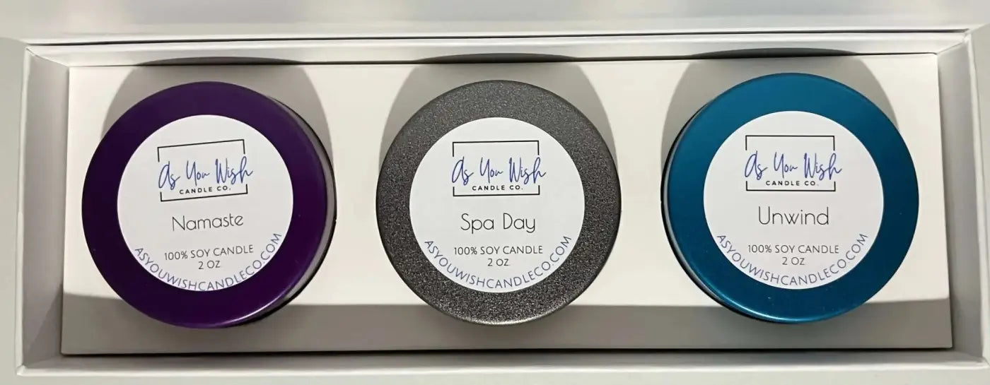 Three round soy candles in purple gray and blue with namaste spa day and unwind labels in the pause collection