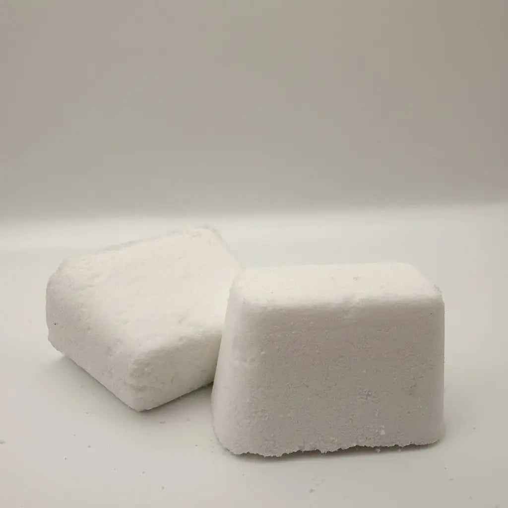 Two white rectangular laundry detergent pods with textured surfaces for use as toilet bowl bombs cleaning product