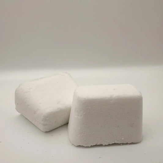 Two white rectangular laundry detergent pods with textured surfaces for use as toilet bowl bombs cleaning product