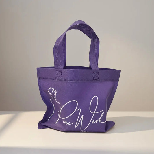 Purple reusable tote bag with white cursive pure wash branding and minimalist woman drawing for soap bundle use