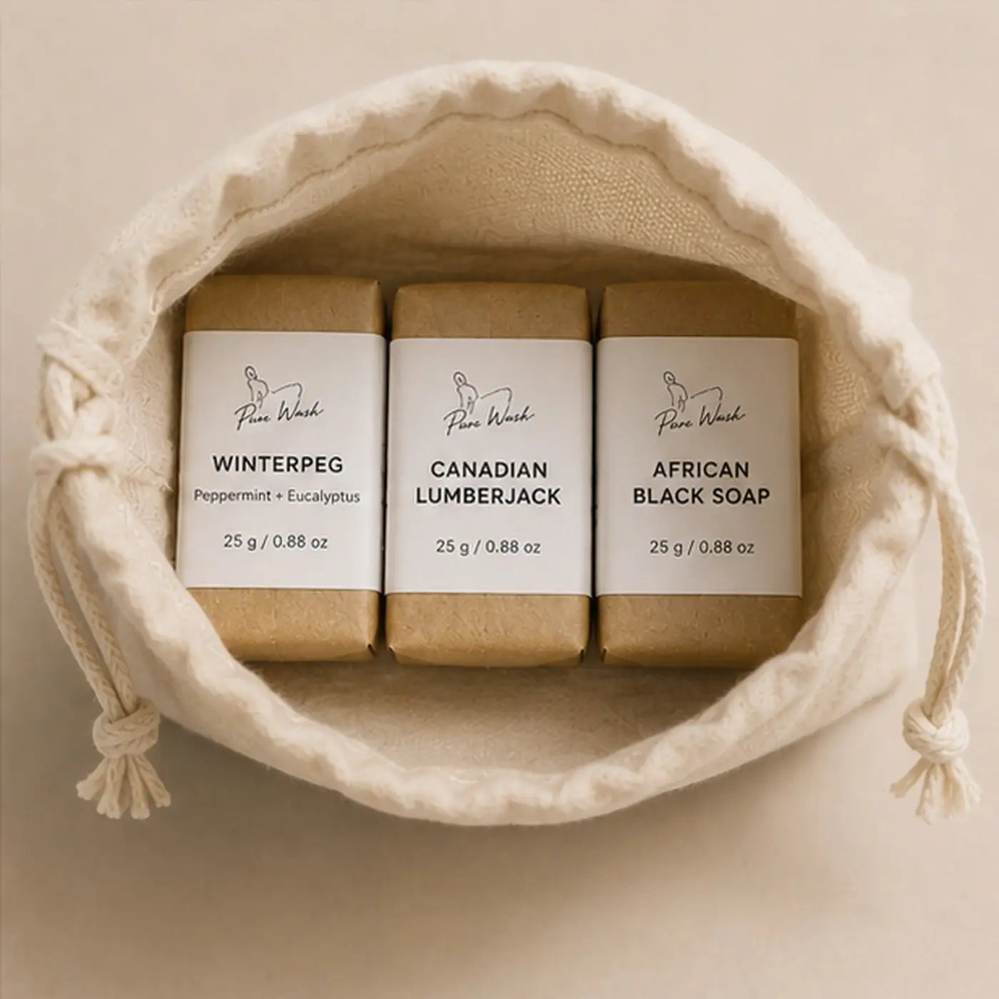 Three travel mini soap bars in brown wrappers labeled winterpeg canadian lumberjack and african black soap pure wash travel bars