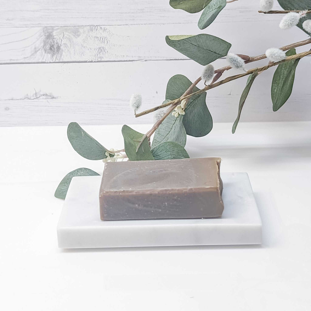 Natural Canadian Lumberjack Soap Bar on a marble tray with botanical backdrop.